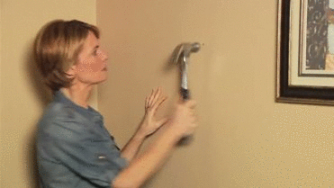 Women Makes Hole In Wall With Hammer